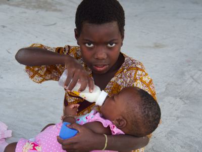 Un niño alimenta a su hermano en la Fundación Ibo