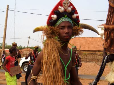 Un chico con máscaras de carnaval en Bissau