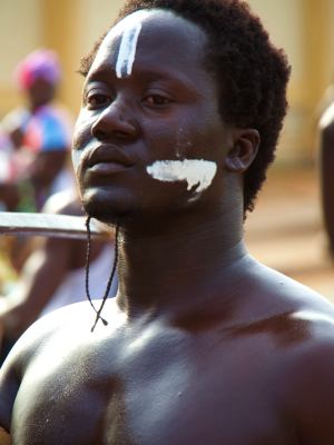 Un chico con señales de guerra en el Carnaval de Bissau