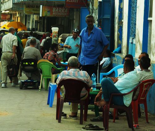Varios grupos de hombres se sientan a la fresca en Mombasa Kenia