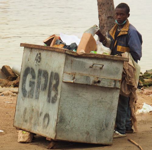 Un hombre busca comida entre las basuras Angola