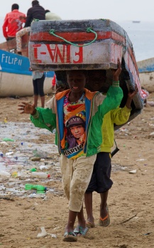 NIÑOS LLEVANDO UNA BARCA EN TOMWA ANGOLA